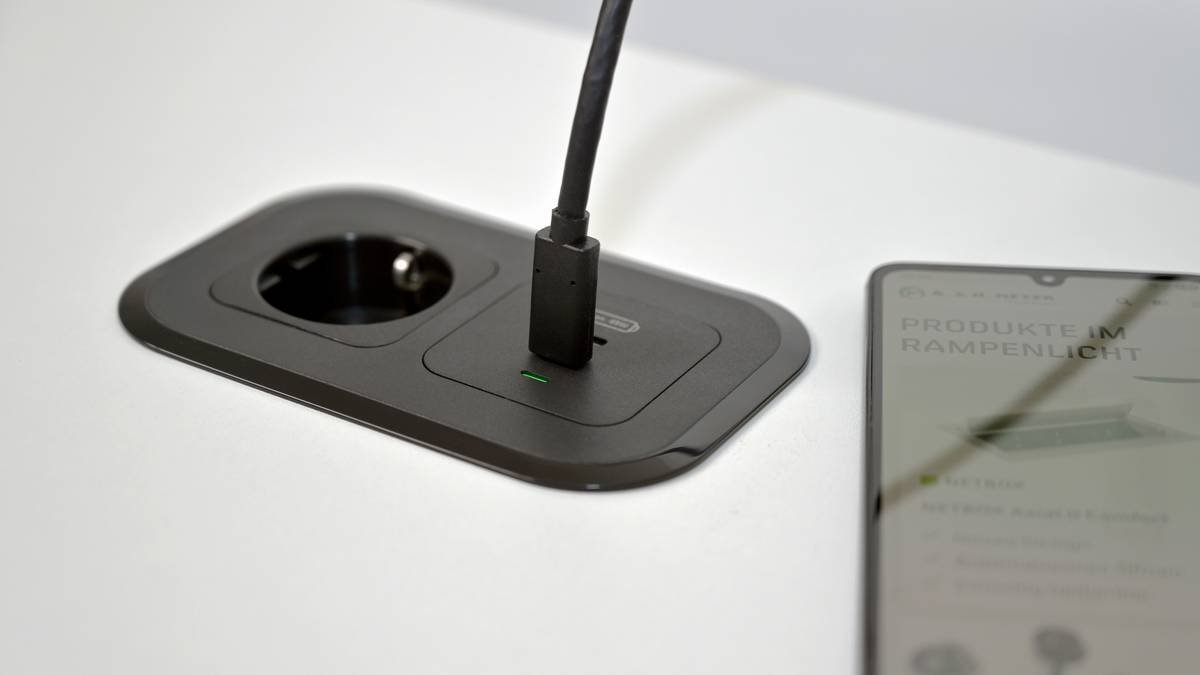 A sleek modern wooden smart table with embedded wireless charging pads and LED indicators